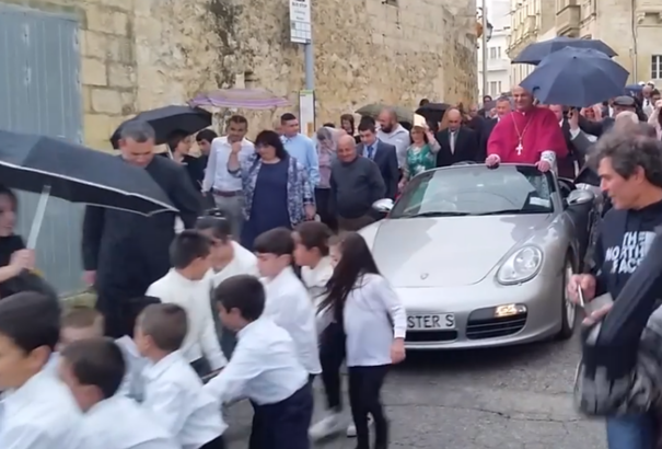 Gyerekek által húzott Porschéból köszöntötte a híveket egy pap (videó)